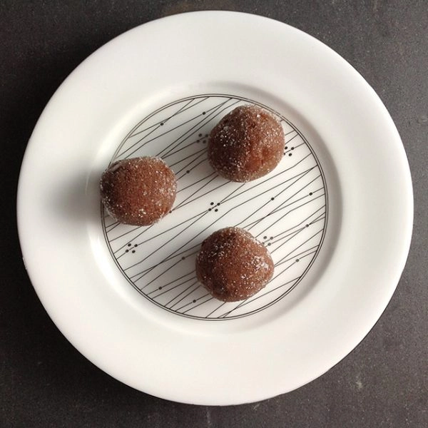 Chocolate truffles on a white plate.